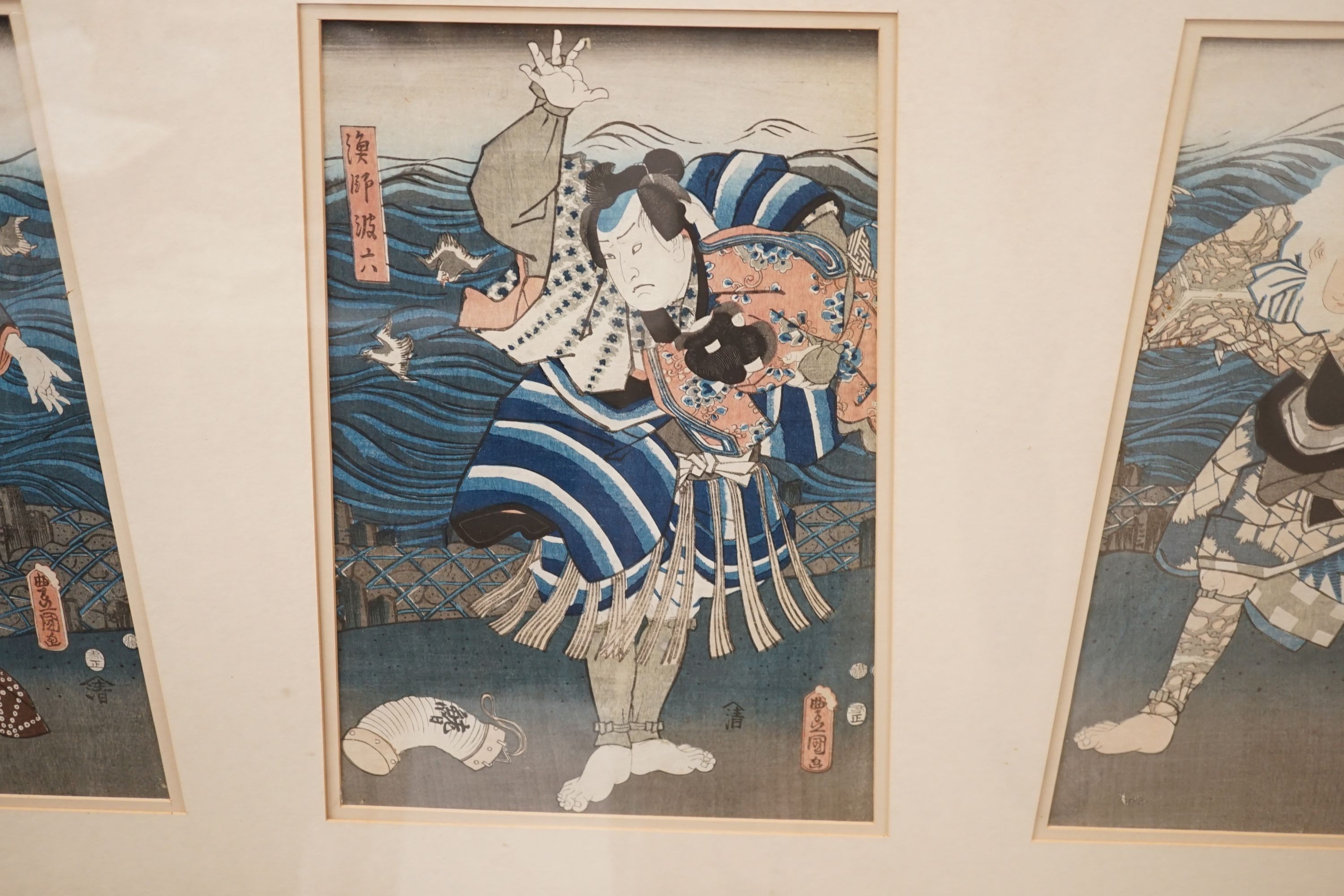 Kunisada, triptych of Japanese woodblock prints, Actors on stage beside the sea, each 35 x 24cm, framed as one